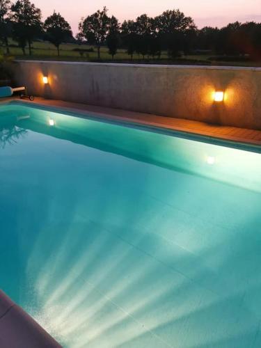 - une grande piscine avec des lumières sur le côté dans l'établissement Gîte de La Pomerie, à Chiché