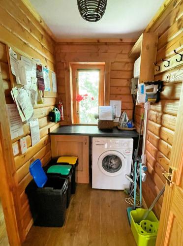 a laundry room with a washing machine in a cabin at Deveron Valley Cottages in Marnoch