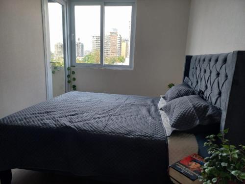 een slaapkamer met een bed en een raam bij Departamento nuevo en pleno centro de Santiago in Santiago