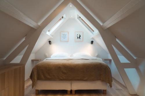 a bedroom with a bed in the attic at Zomerhuis aan Zee in Noordwijk aan Zee