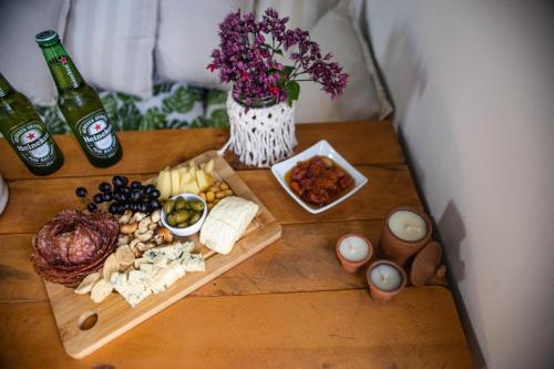 a table with cheese and other food and bottles of beer at Zero Meia Um Pousada in São Miguel do Gostoso