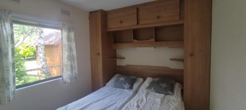 a small bedroom with a bed and a window at Zacisze nad Sanem 129 a in Załuż