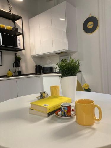 una tazza gialla da caffè e un libro sul bancone della cucina di Bike&The City a Ferrara