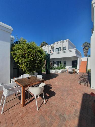 a patio with a table and chairs and a building at Langholm Hotel in Walvis Bay