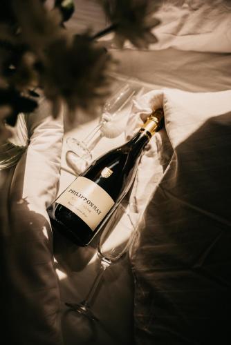 a bottle of wine sitting on top of a bed at Hotel Millenium in Żyraków