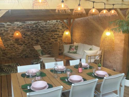 a dining room with a table and chairs and lights at La Bohème. Maison de village cosy, jardin et spa. in Octon