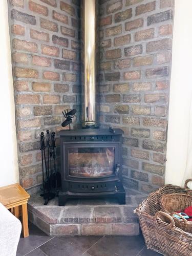 a fireplace in a brick wall with a stove at Deveron Valley Cottages in Marnoch
