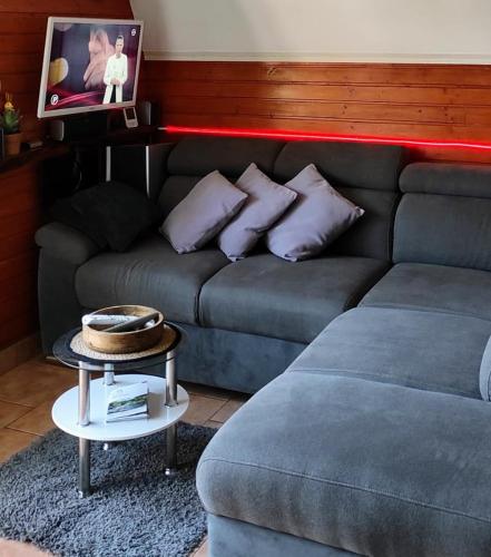 a living room with a couch and a table at Planinska vikendica LUCIJA in Fužine