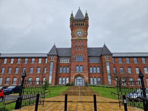 a large red brick building with a clock tower at Birch Hill Clock Tower in Rochdale