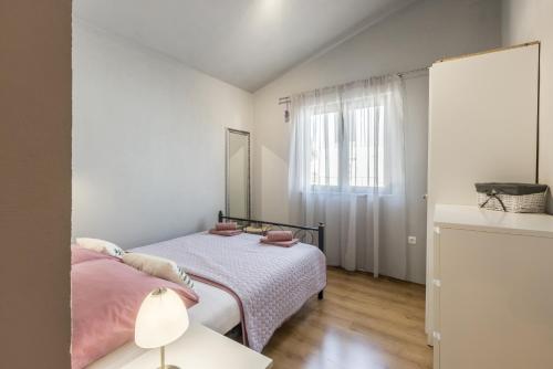 sypialnia z 2 łóżkami i oknem w obiekcie Apartment LaMaro w mieście Kaštela