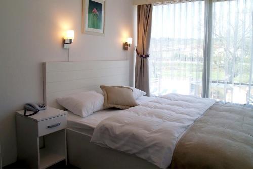 a bedroom with a large white bed with a window at Bodega Butik Otel Şile in Sile