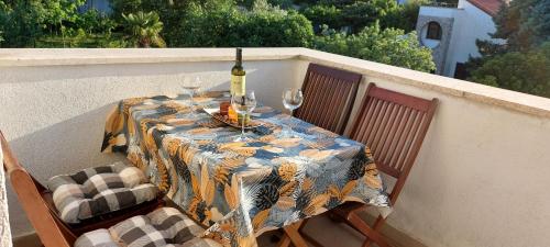 a table with a bottle of wine and glasses on a balcony at Green Villa in Banjole