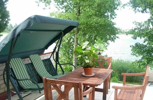 a table and chairs with a umbrella on a patio at Ezerkiemis in Trakai