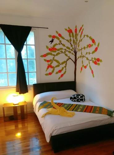 a bedroom with a tree mural on the wall at Hotel Boutique Spa Villa de Sant in Quito