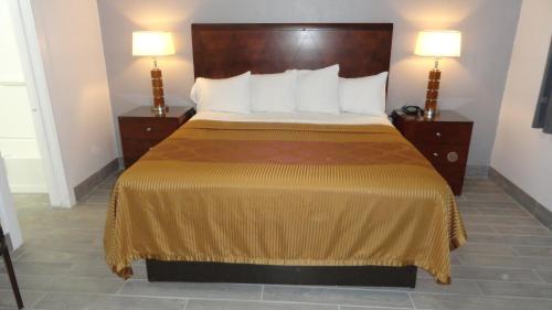 a bed in a hotel room with two night stands at ECONOMY INN in Brownfield