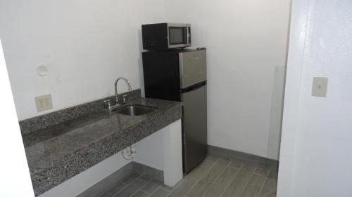 a kitchen with a sink and a microwave on a refrigerator at ECONOMY INN in Brownfield