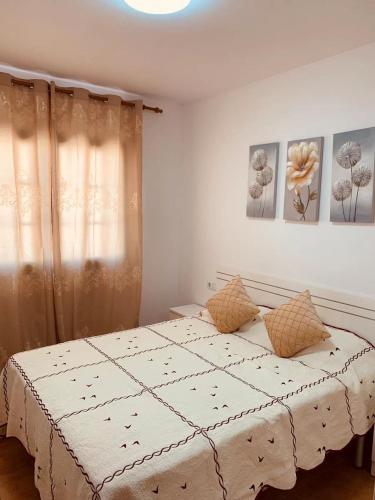 a bedroom with a white bed with two pillows at Lin House in Corralejo