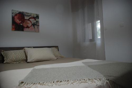 a bed in a bedroom with a picture on the wall at Aelia in Agios Vlasios