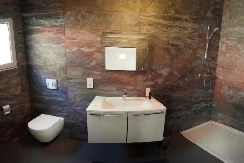 a bathroom with a sink and a toilet at Le Logis du pêcheur in La Cotinière