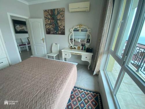 Schlafzimmer mit einem Bett, einem Tisch und einem Spiegel in der Unterkunft Amore Beach элитный готельный комплекс in Elenite