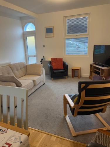a living room with a couch and a tv at Eleven Upway Street in Weymouth