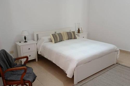 - une chambre blanche avec un lit blanc et une chaise dans l'établissement Luxury Penthouse, 50m2 terrace, downtown, à Santa Cruz de Tenerife