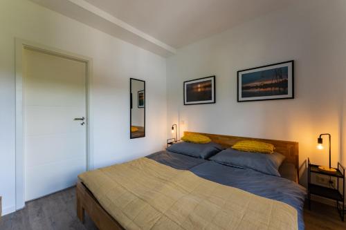 a bedroom with a bed and two pictures on the wall at Ferienwohnung am Steinbach 1 in Thale
