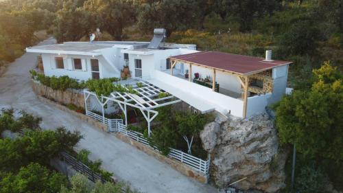 uma vista aérea de uma casa branca sobre uma rocha em Mano's House em Triopetra