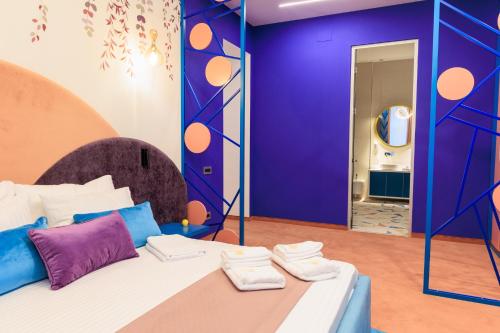 a room with a bed with purple walls and a mirror at Vilacrosse Boutique Inn in Bucharest