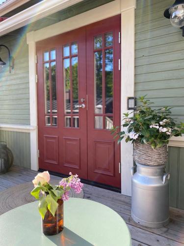 a red door on a house with a table and flowers at Eleonora Bed & Breakfast in Kristiinankaupunki