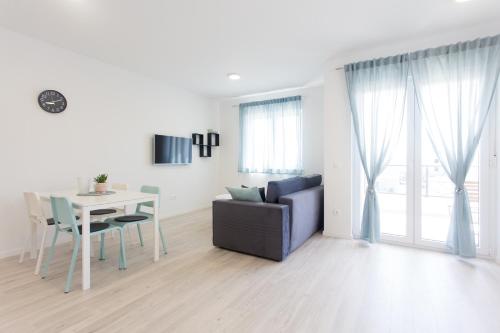 a white living room with a table and a couch at Delminium in Kaštela