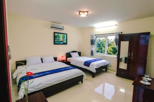 1 dormitorio con 2 camas y ventana en Harmony Hoian Homestay, en Hoi An