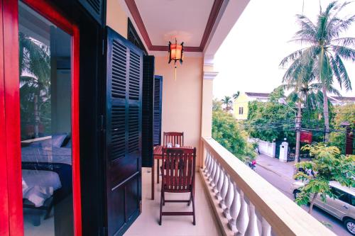 a balcony with a chair and a view of a street at Harmony Hoian Homestay in Hoi An