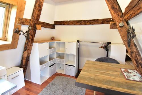 Cette chambre dispose d'étagères blanches et d'une table. dans l'établissement Le Duplex Carnot, à Annecy