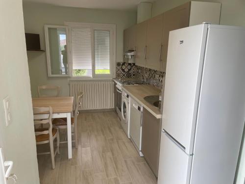 une cuisine avec un réfrigérateur blanc et une table dans l'établissement APPARTEMENT MESSINA, à La Ciotat