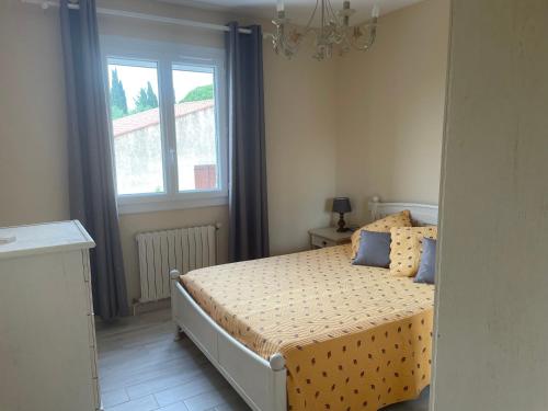 une chambre avec un lit avec des oreillers bleus et une fenêtre dans l'établissement APPARTEMENT MESSINA, à La Ciotat