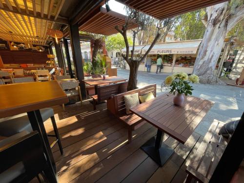 una terraza de madera con mesa y sillas de madera en L'Oustaou De Porquerolles, en Porquerolles