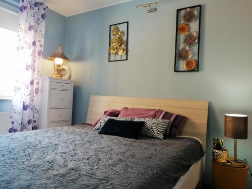 - une chambre avec un lit et trois photos sur le mur dans l'établissement Orange Water Apartment, à Gdańsk