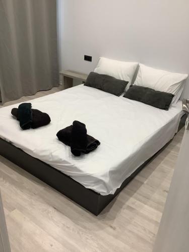 uma cama com dois chapéus pretos em cima em New apartment em Tessalônica