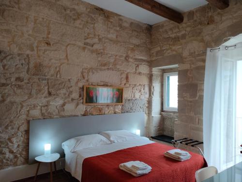 a bedroom with a bed with a red blanket at Bella Giulia in Ragusa