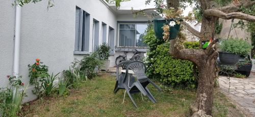 a table and a chair sitting next to a tree at Studio indépendant, avec piscine et jardin, direct gare aéroport, 1 lit pour 2 personnes Direct Gare Aéroport in Toulouse