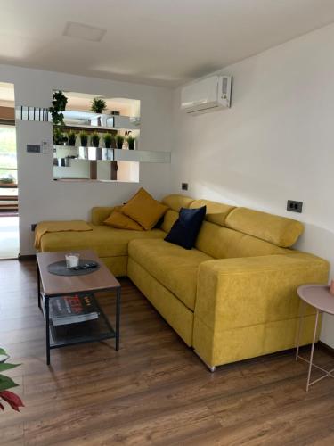 a living room with a yellow couch and a table at Zeta-house on the lake, wellness&spa in Legrad