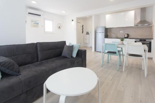 a living room with a couch and tables and a kitchen at Delminium in Kaštela
