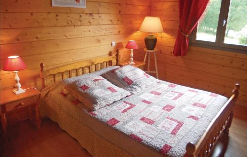 a bedroom with a bed in a log cabin at Nice Home In Sceau-saint-angel With 3 Bedrooms, Private Swimming Pool And Outdoor Swimming Pool in Nontron
