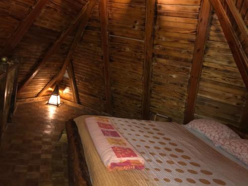 una camera con letto in una mansarda in legno di Brvnare Dolic a Sarajevo