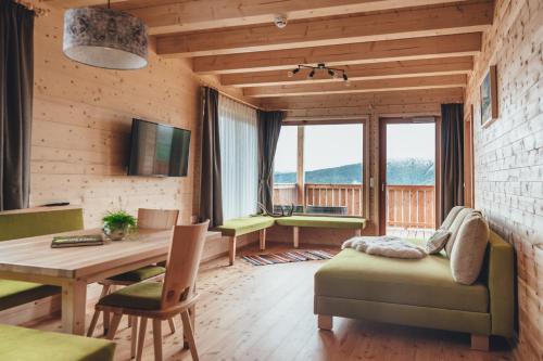 a living room with a table and chairs and a dining room at Hiasl Zirbenhütte in Hochrindl