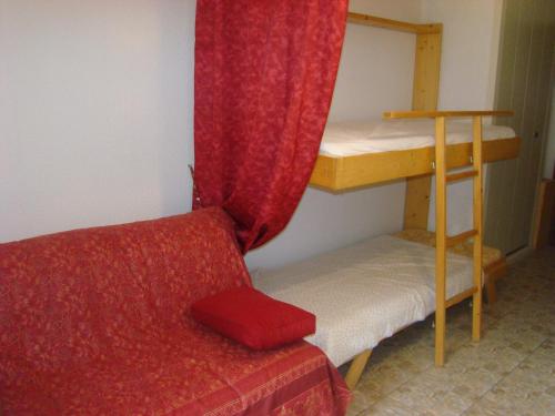 - une chambre avec des lits superposés et un canapé rouge dans l'établissement Studio au calme face aux montagnes dans station de ski, à La Morte