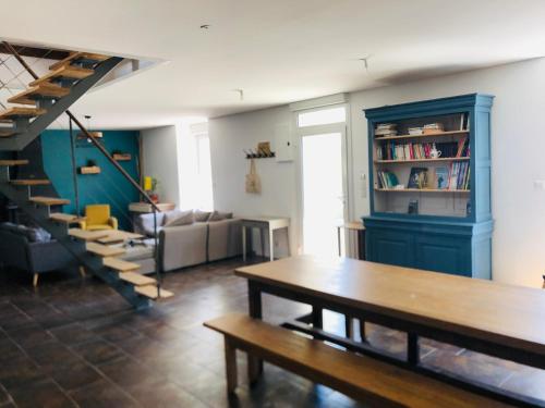 un salon avec une table et une étagère bleue dans l'établissement La Plooz, à Plozévet