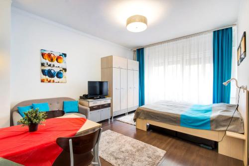 a bedroom with a bed and a table and a television at Károlyi street - central location quiet place 2ppl in Budapest