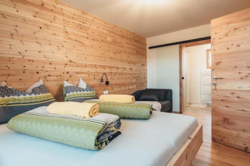 a bedroom with two beds and a wooden wall at Hiasl Zirbenhütte in Hochrindl